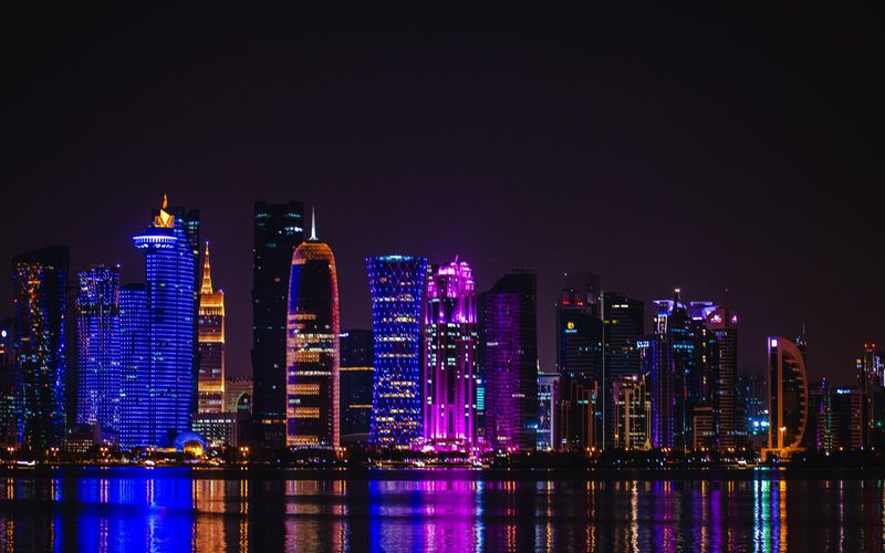 Doha skyline lit up at night across the water