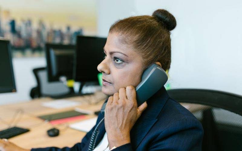 Customer support agent speaking on the office phone